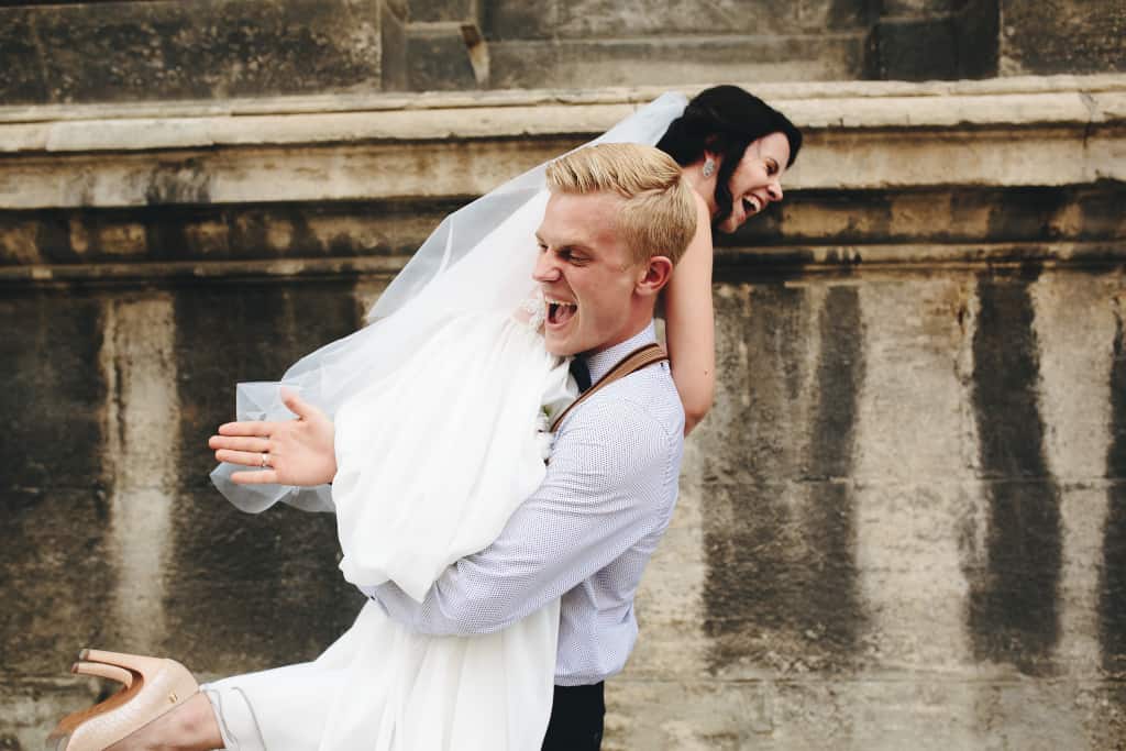 Groom carries bride after courthouse wedding